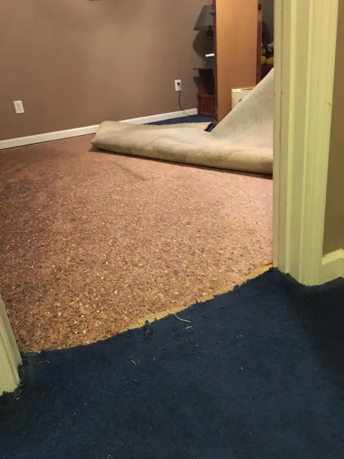 Carpet pad removal revealing water damage during Water Mitigation Services in Topeka